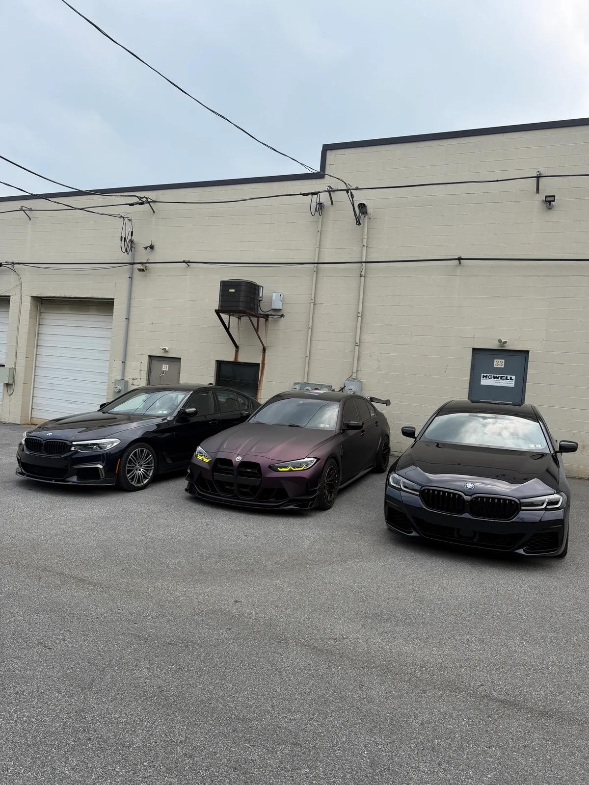 Three detailed BMWs lined up outside the shop — GNelson Detailing