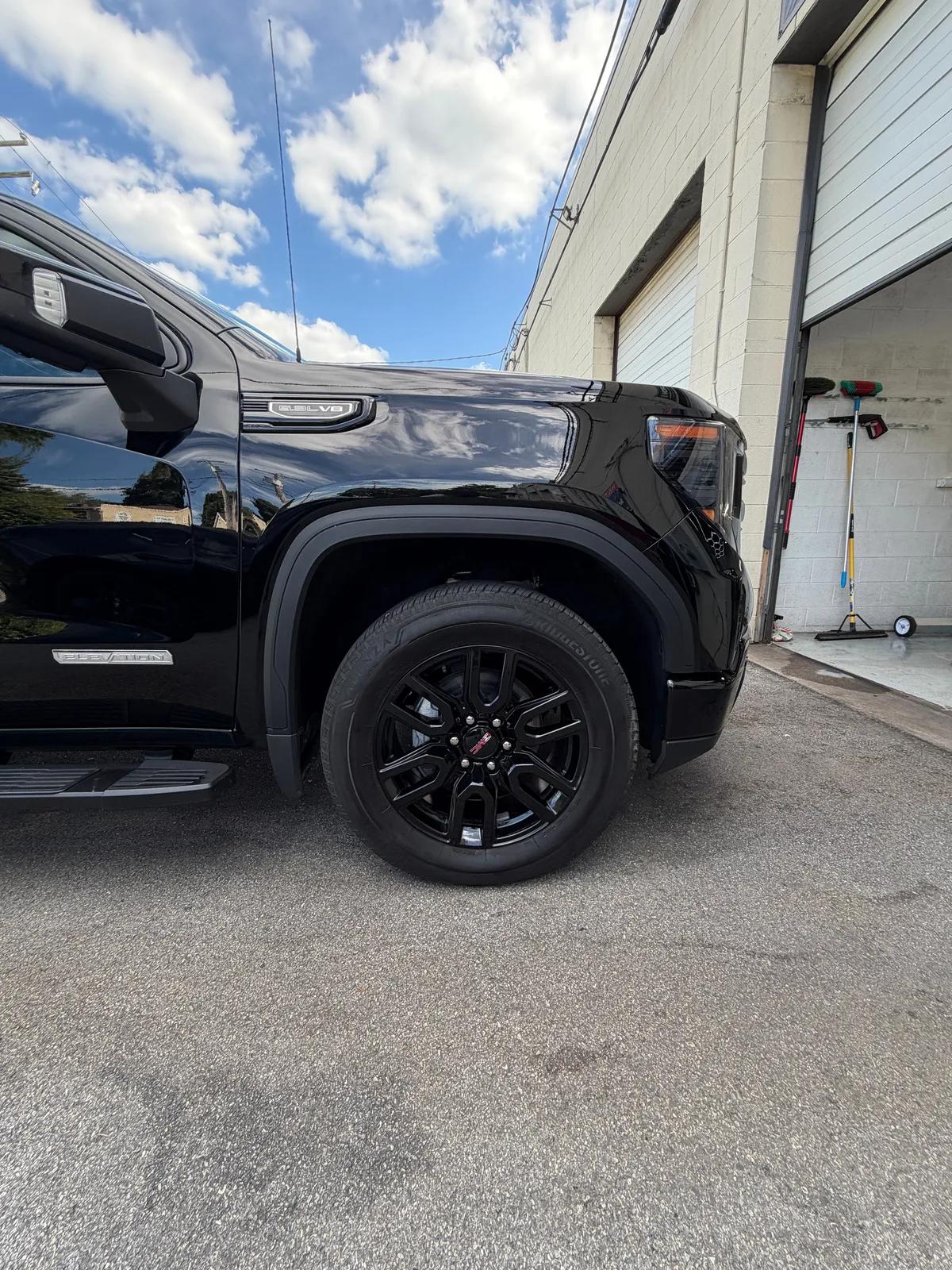 Close up of a cleaned wheel and fender on a black GMC Sierra. GNelson Detailing West Chester PA