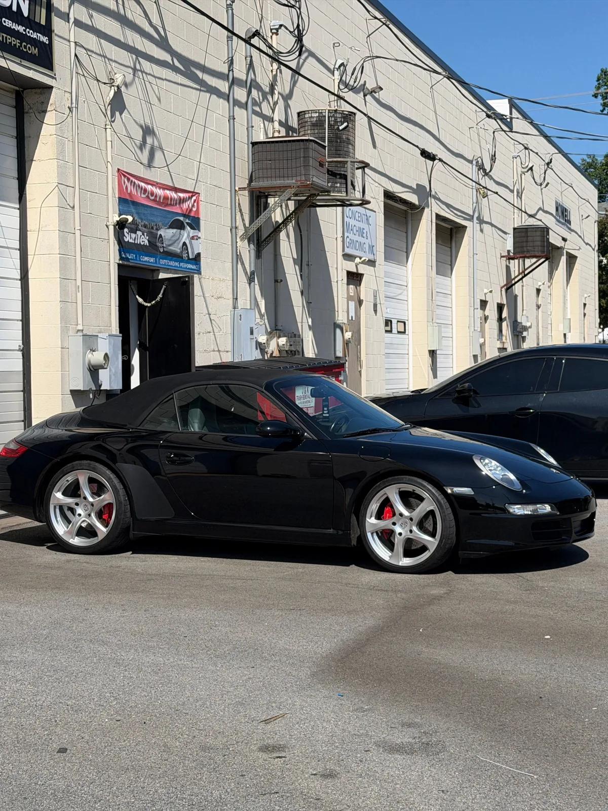 Black Porsche 911 cabriolet in profile outside the shop after ceramic coating. GNelson Detailing West Chester PA
